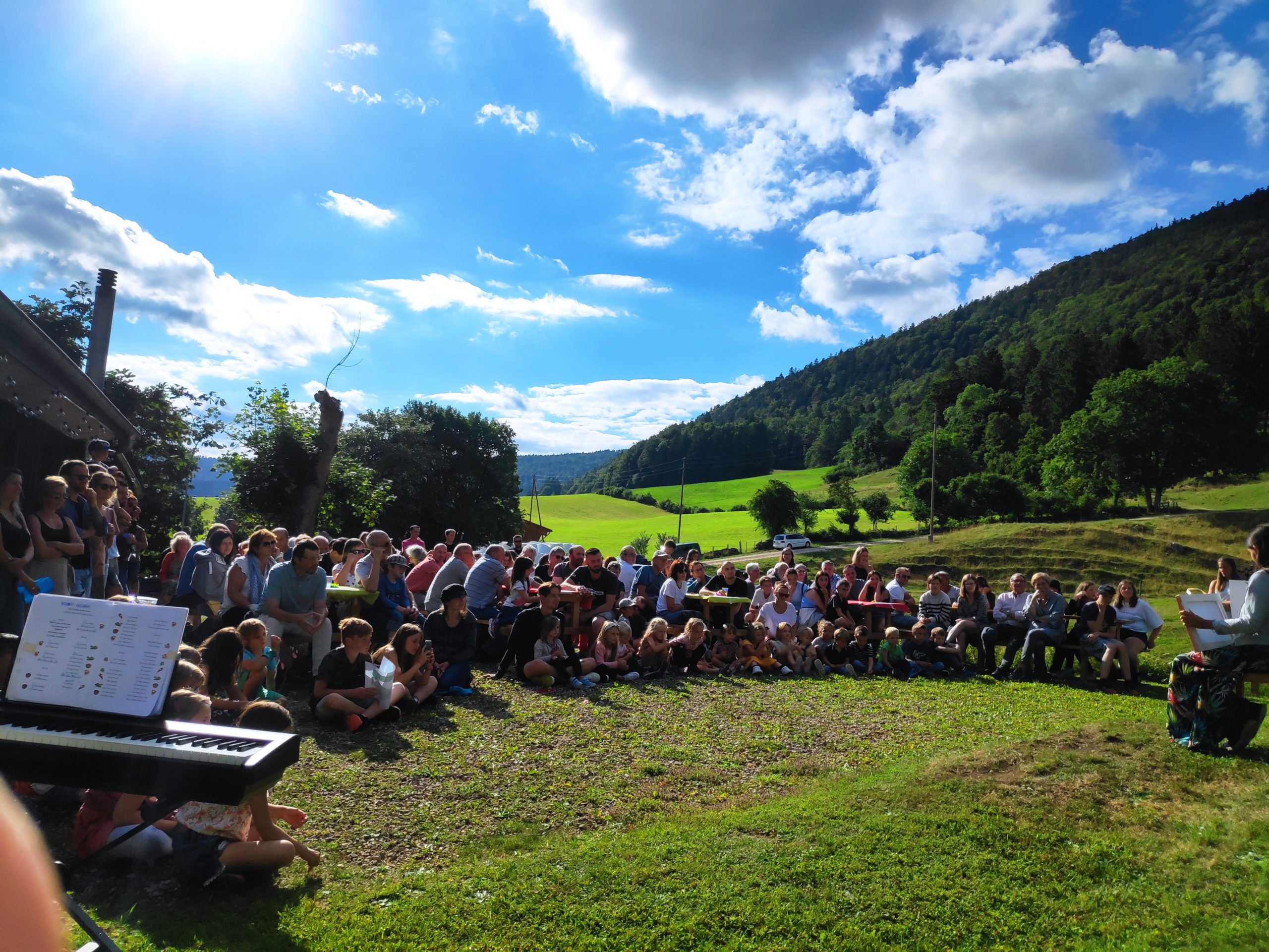 Groupe en extérieur avec montagnes, ciel partiellement nuageux et clavier au premier plan.