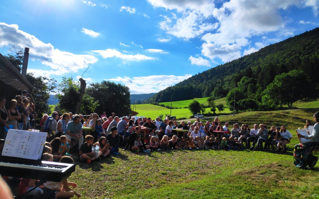 Groupe en extérieur avec montagnes, ciel partiellement nuageux et clavier au premier plan.